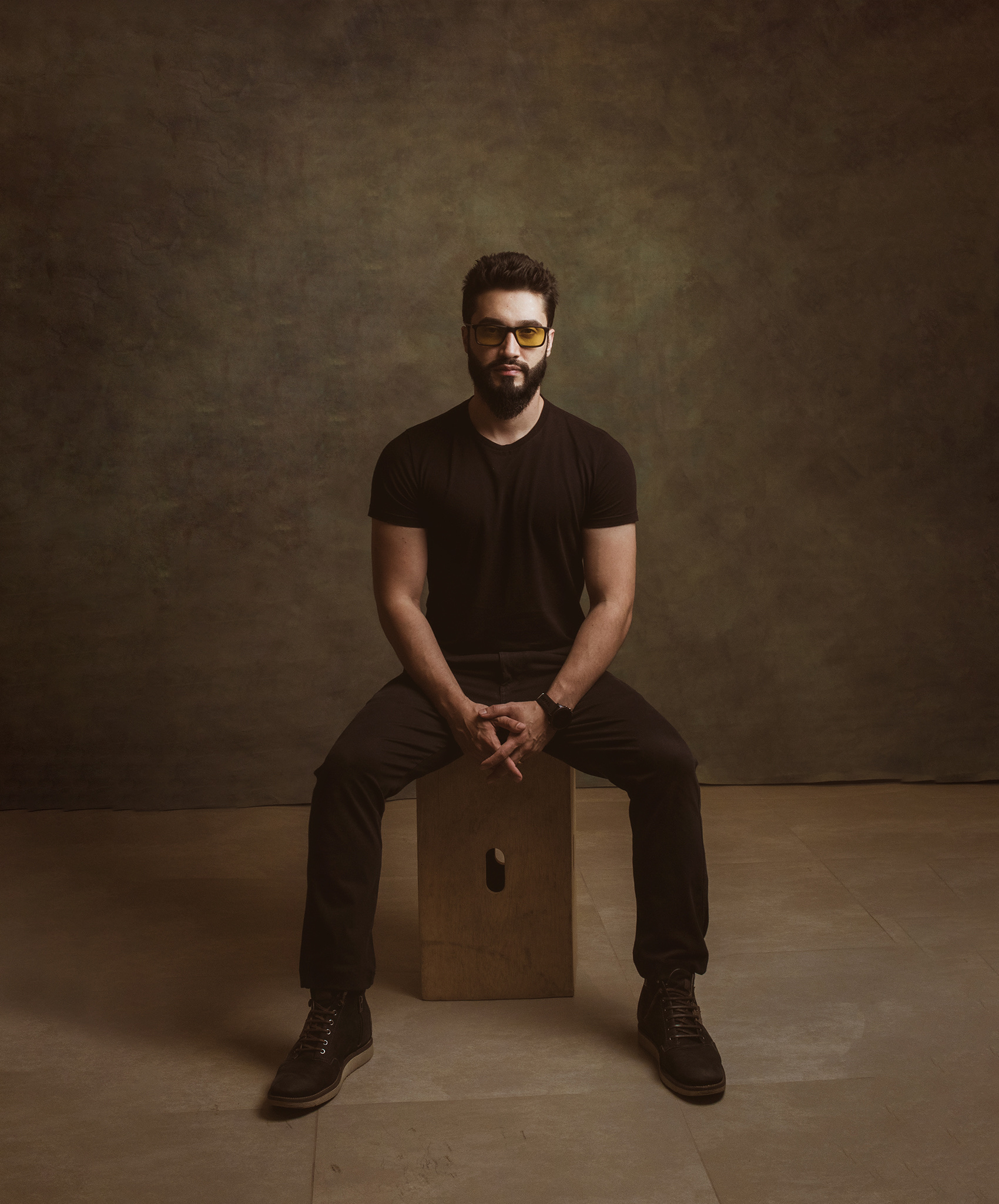 Alan Nicolas, retrato de estúdio, sentado, vestido de preto