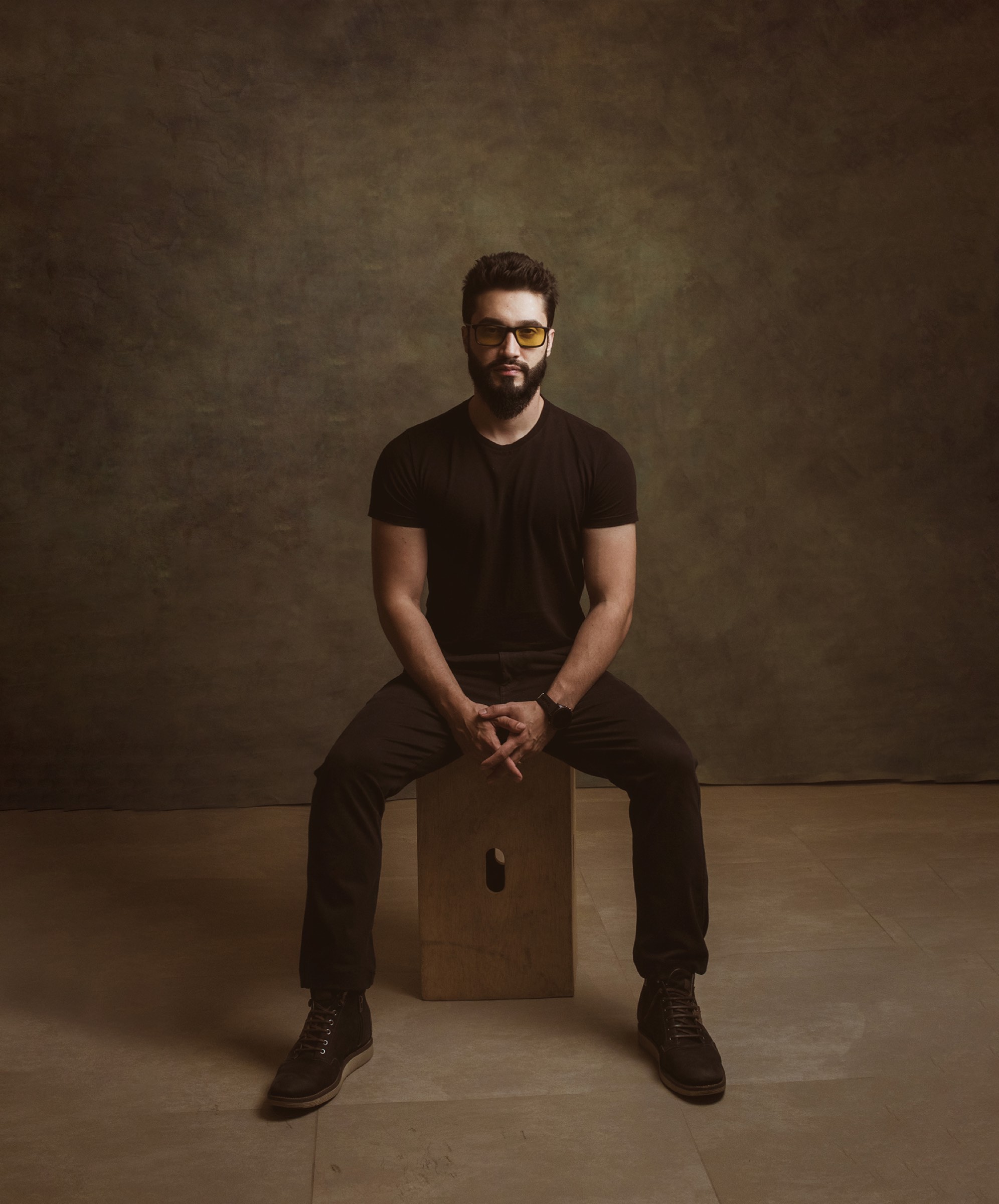 Alan Nicolas, retrato de estúdio, sentado, vestido de preto
